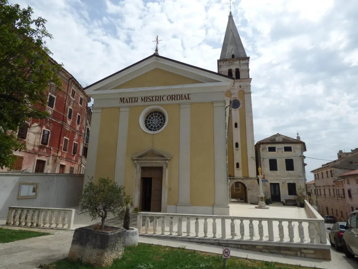 Yellow Mater Misericordiae church and its stone bell tower in Buje