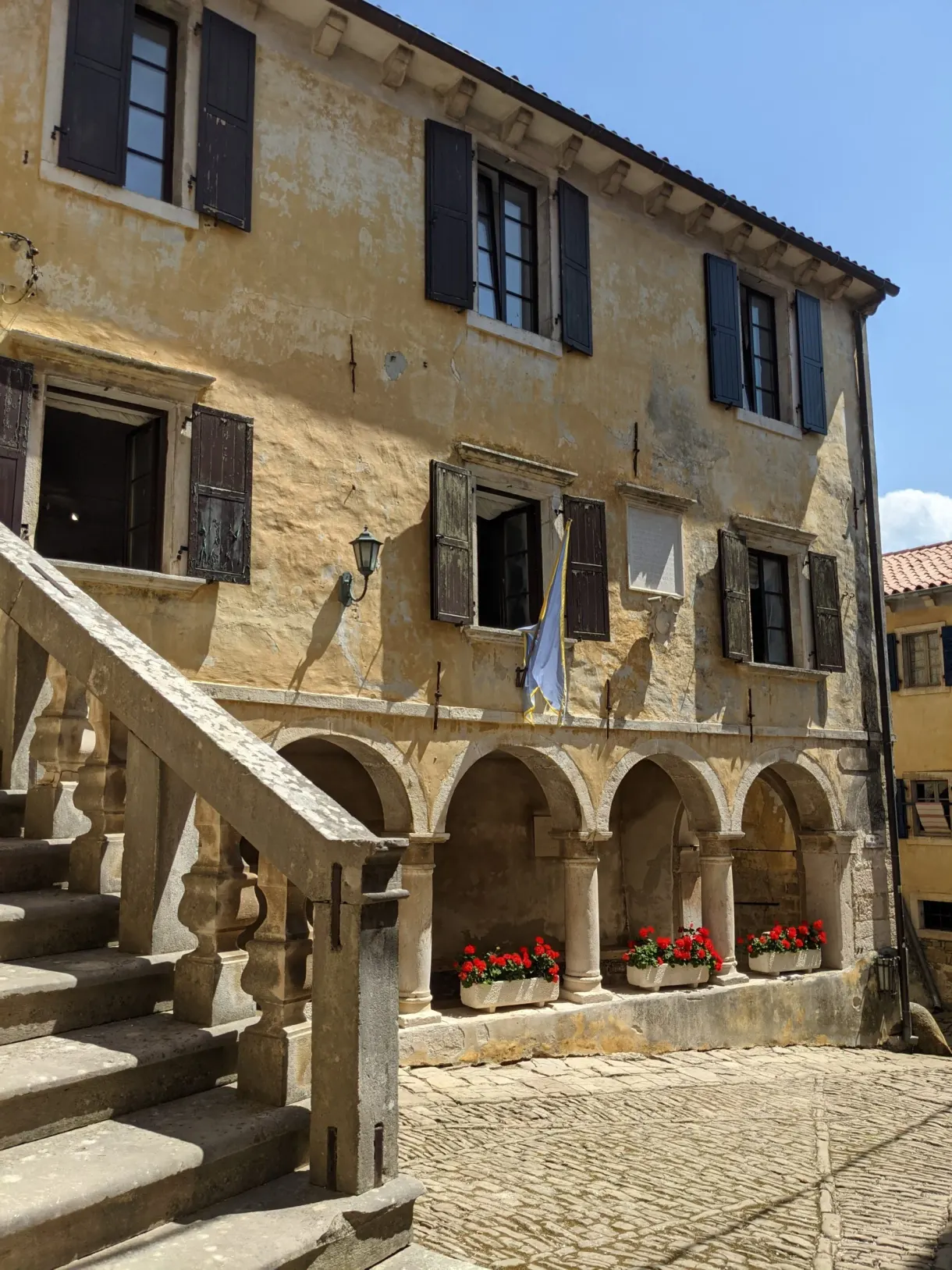 Ochre house with outside staircase and flowered arcades in Grožnjan