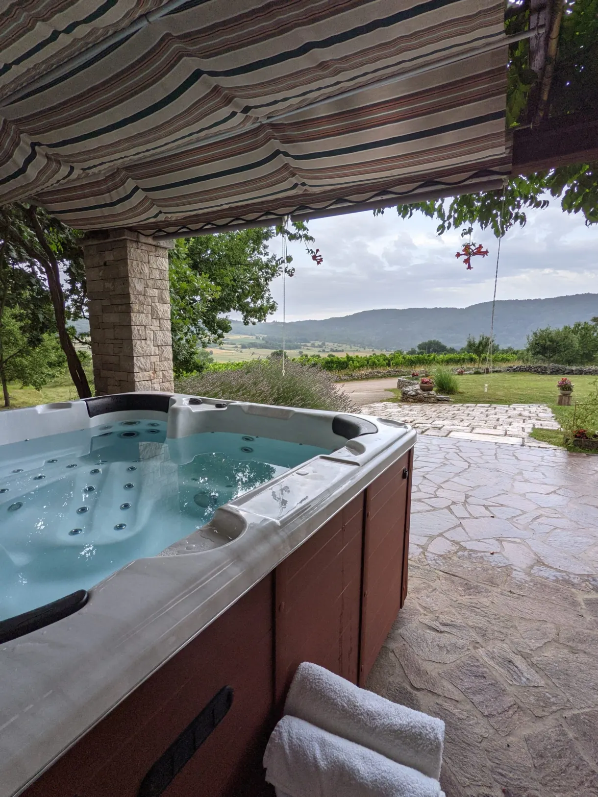 Hot tub set up under a pergola facing the vineyards