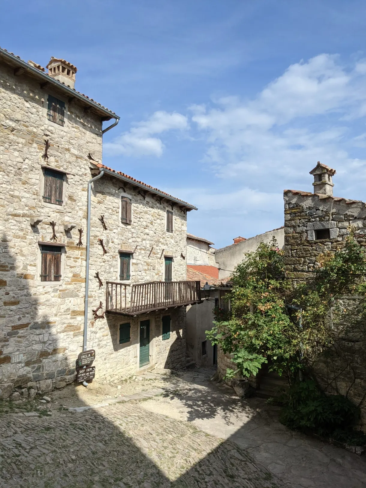 Stone houses packed along a sloping lane in Hum