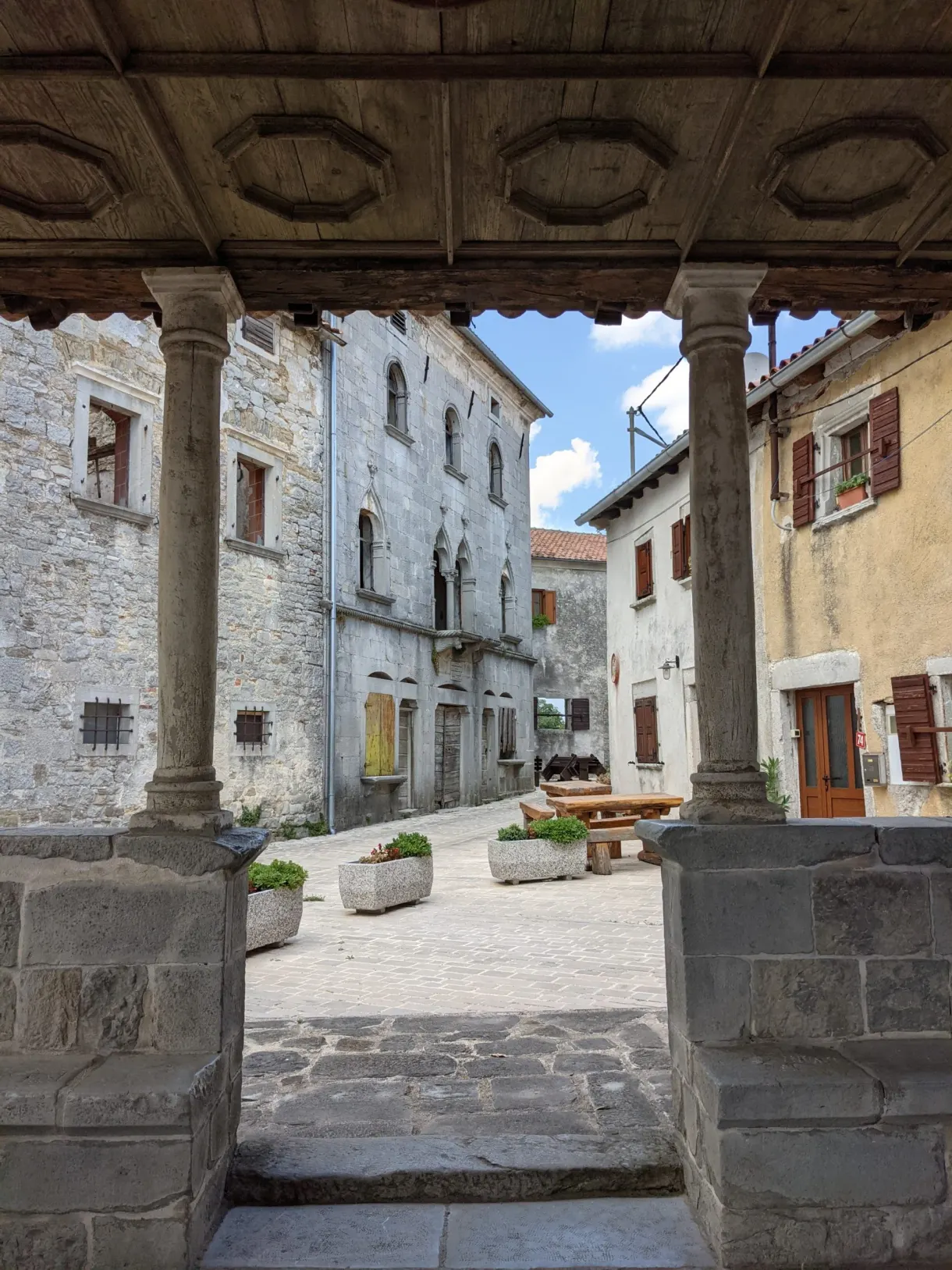Village square framed by the timber frame of a loggia in Gračišće