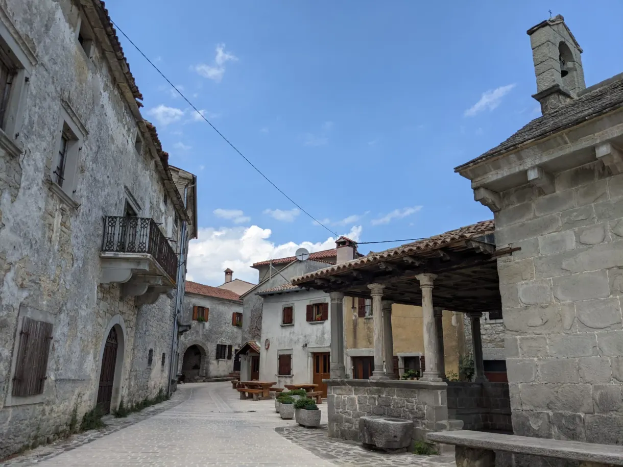 Stone houses and small bell tower along a street in Gračišće