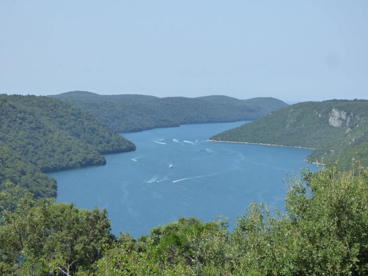 Boats gliding over the blue waters of the Lim channel