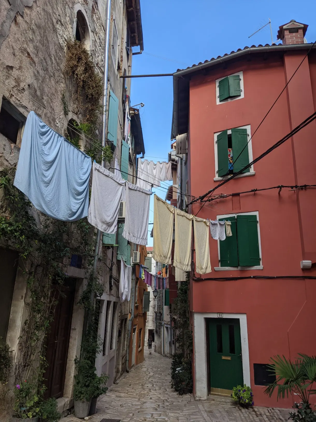 Washing hung across a lane with red façades in Rovinj