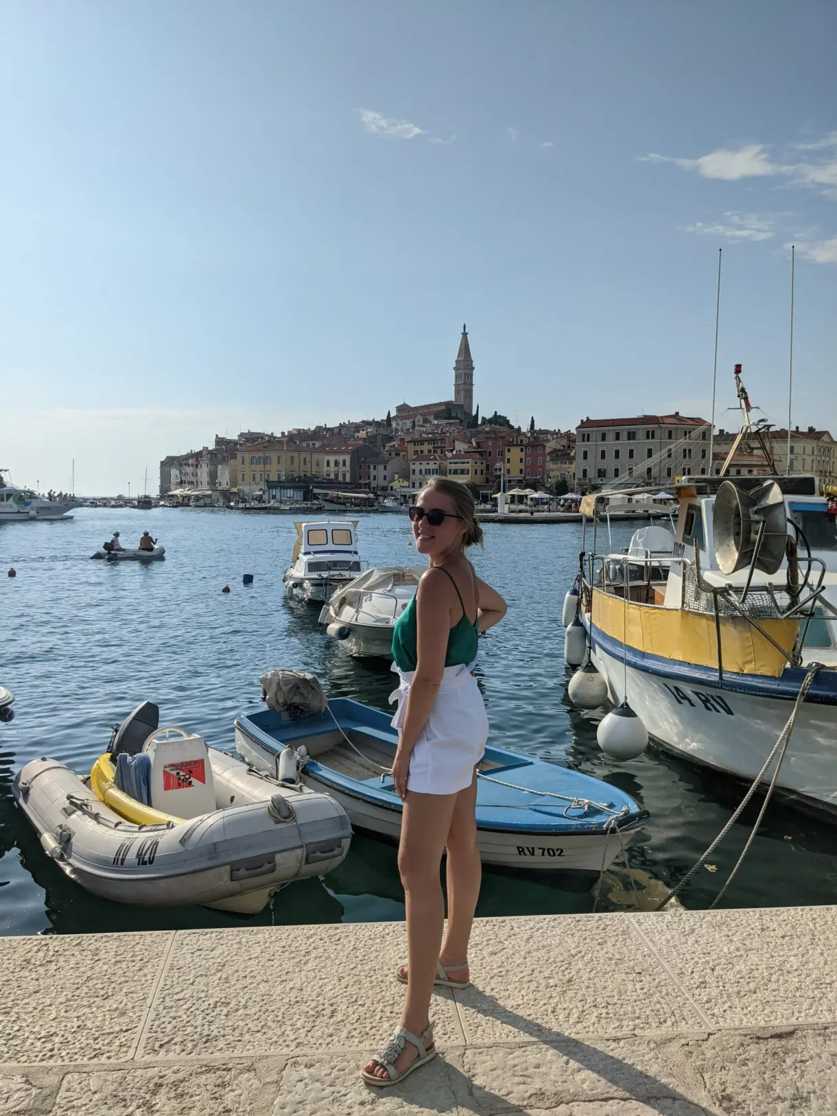 Woman on the quay in Rovinj in front of the boats and the old town