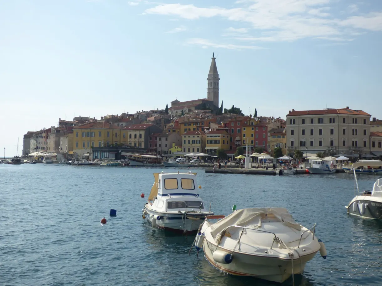 Boats moored in front of the silhouette of Rovinj on the sea