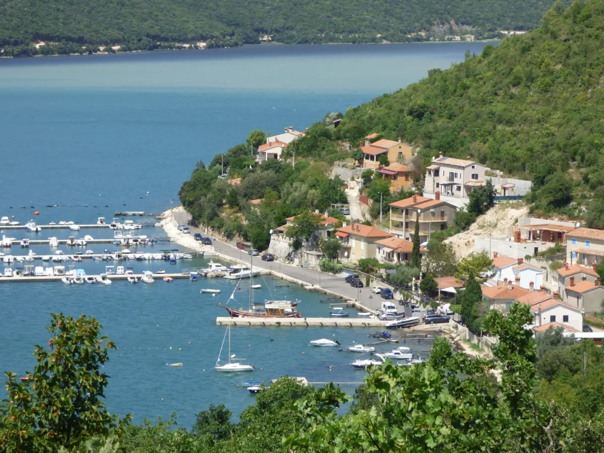Houses with tiled roofs and pontoons at the edge of the bay of Trget