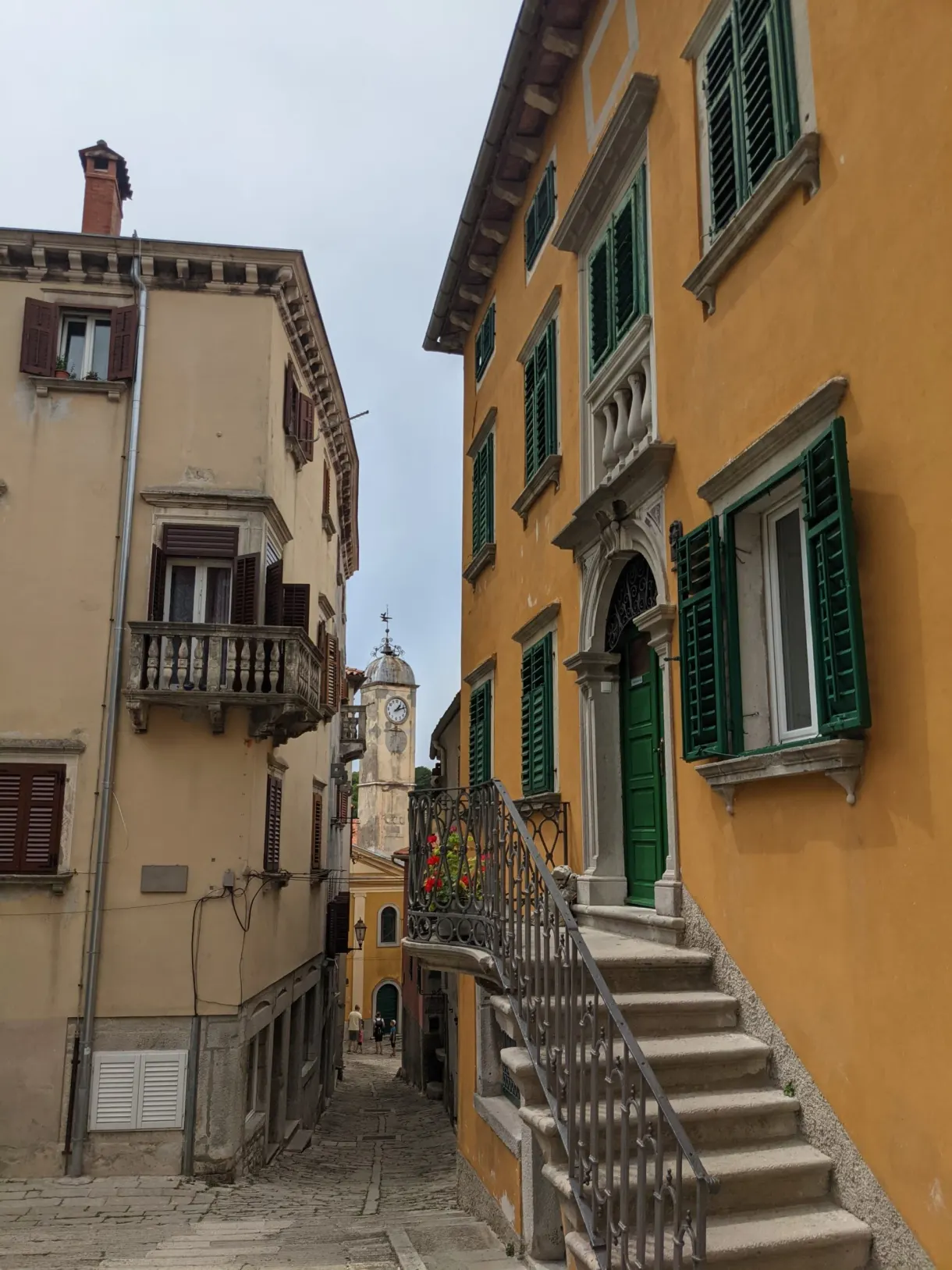 Yellow house with green shutters and its stone staircase, Labin