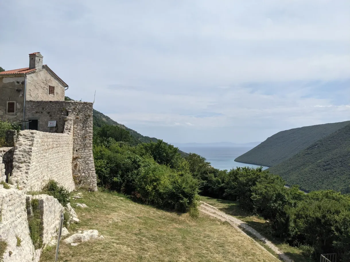 Stone remains of Plomin overlooking the sea and the wooded cape