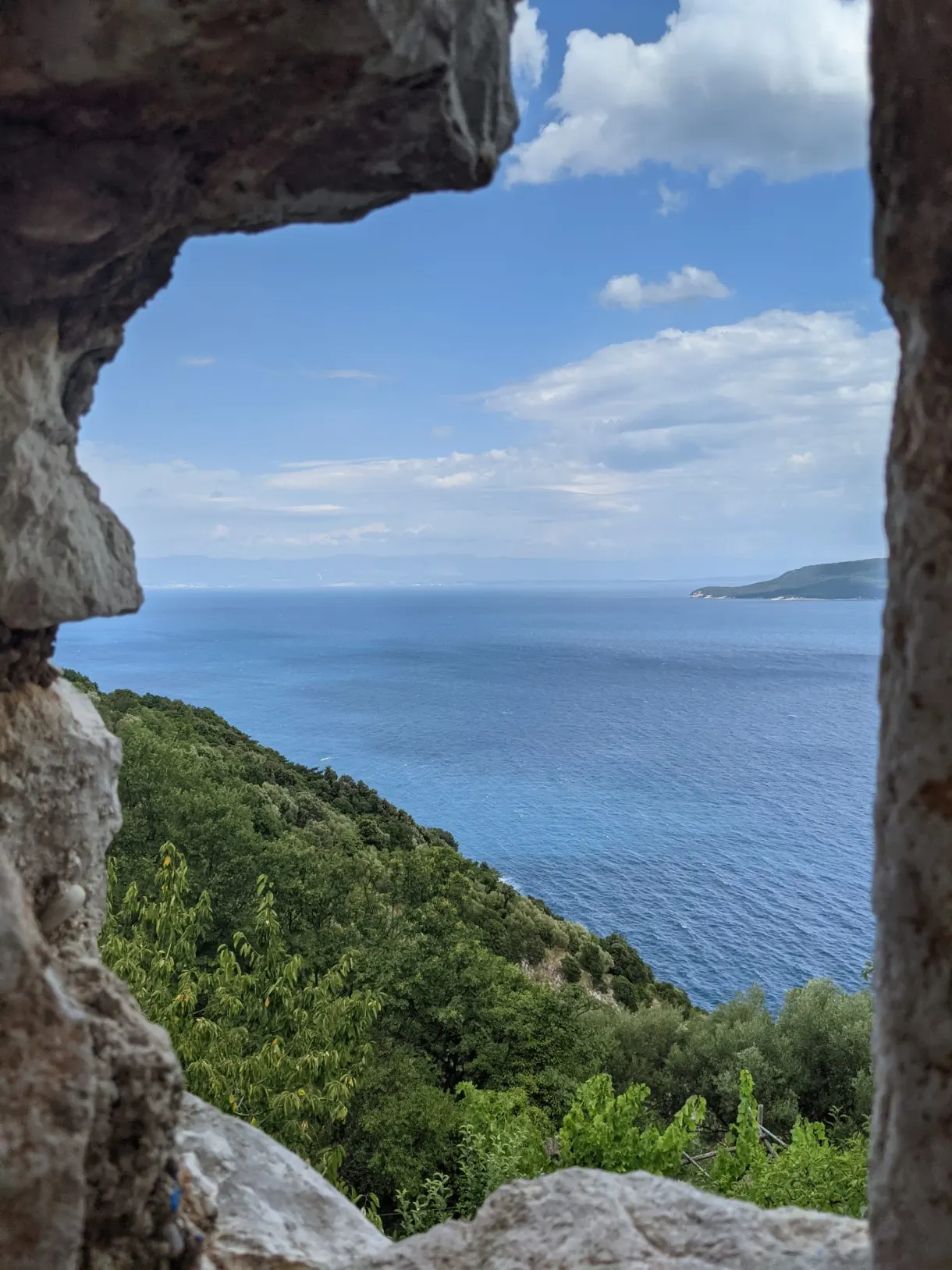 Gap in a stone wall opening onto the sea in Brseč