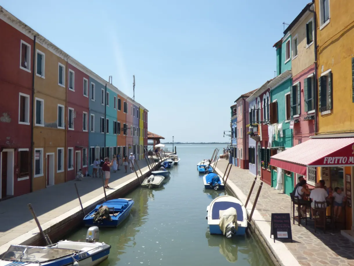 Canal de Burano bordé de maisons vives et d'une terrasse
