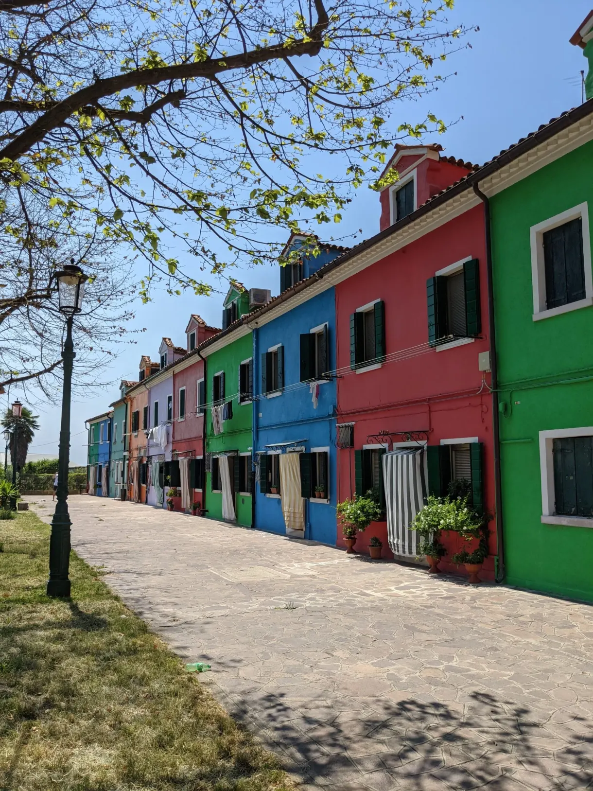 Rangée de maisons bleues, vertes et rouges le long d'une rue