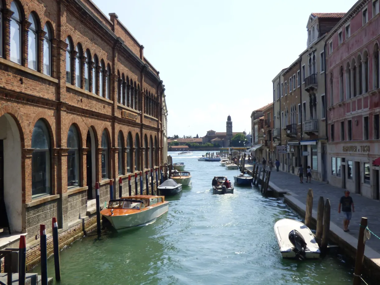 Long bâtiment à arcades au bord d'un canal animé
