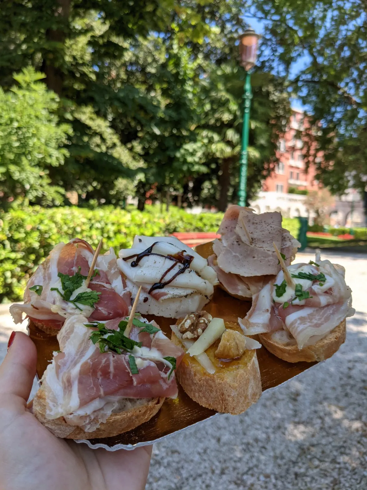 Main tenant des cicchetti garnis de charcuterie et de crème