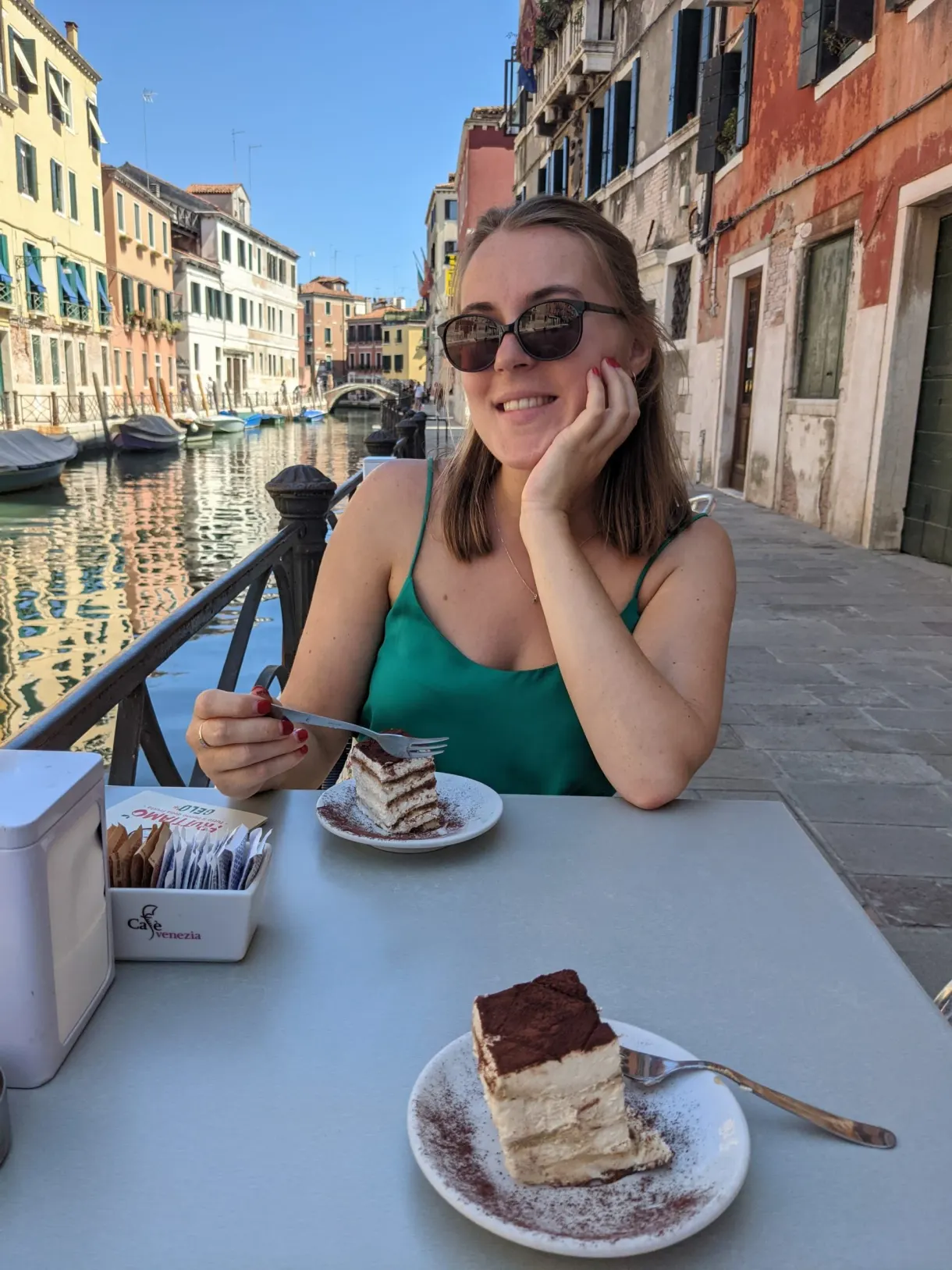 Attablée en terrasse devant un tiramisu, canal en arrière-plan