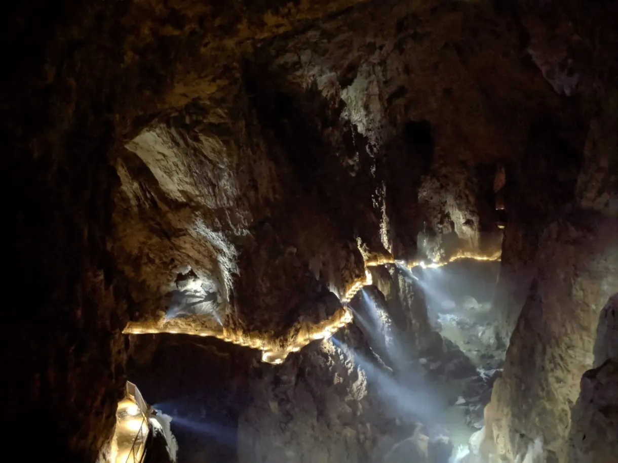 Vaste canyon souterrain traversé de faisceaux lumineux