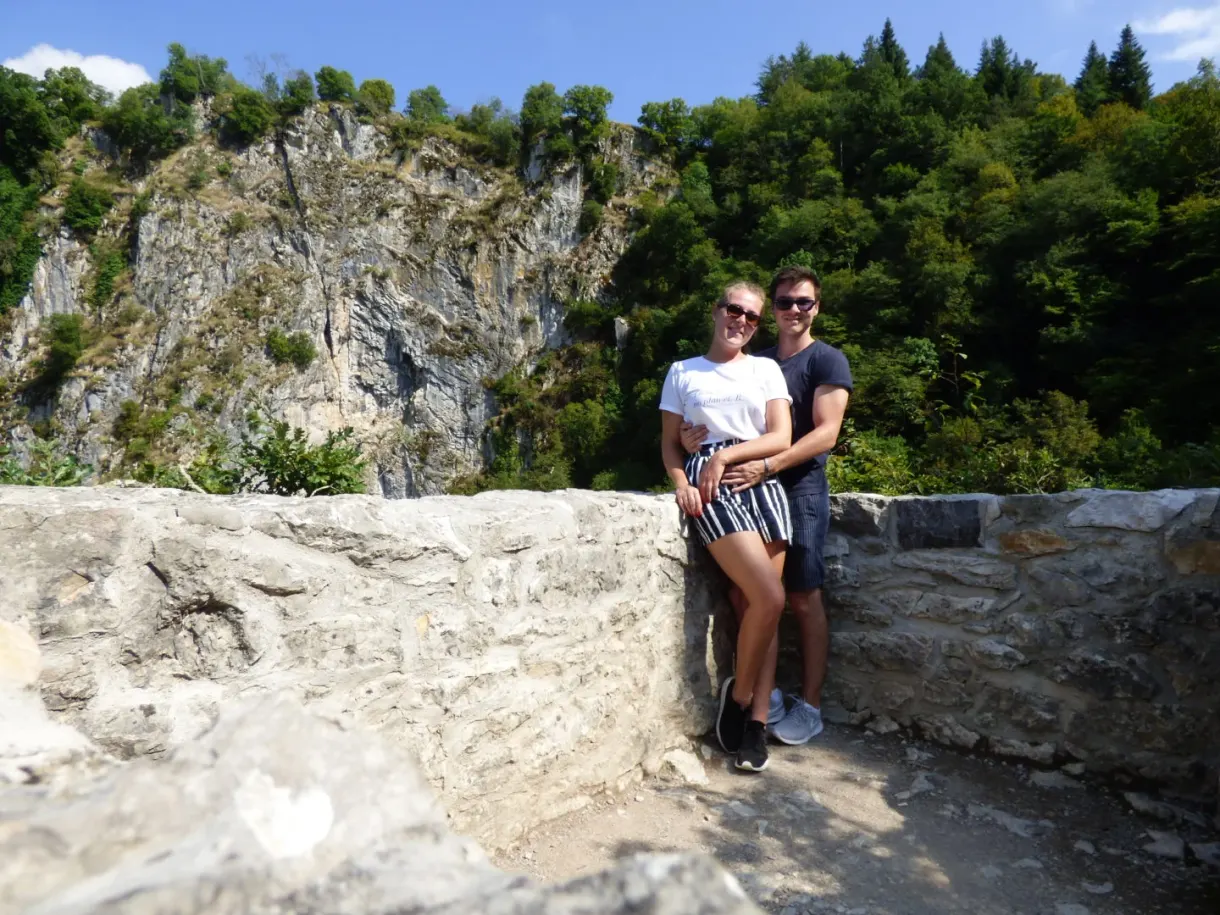 Couple posant contre un muret devant le gouffre