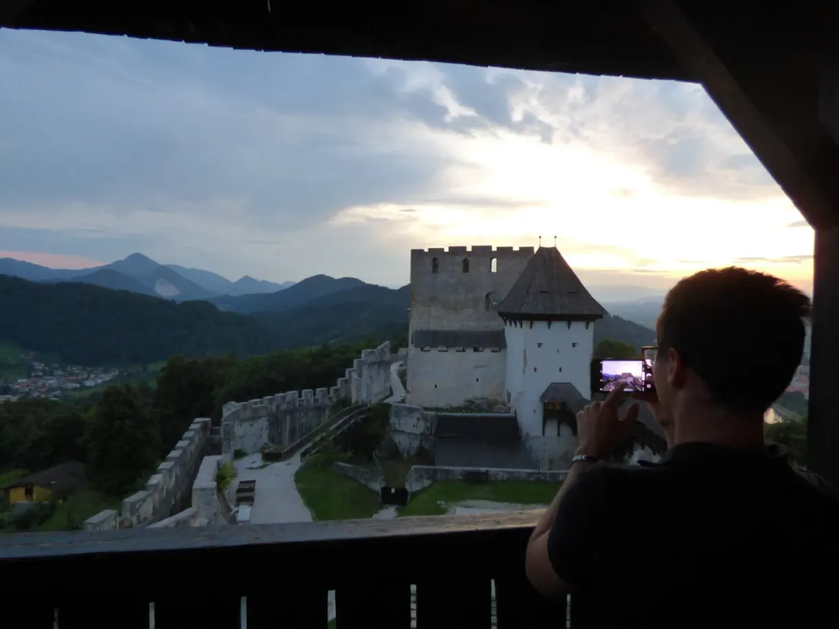 Figure photographing the castle from a dark opening in the tower
