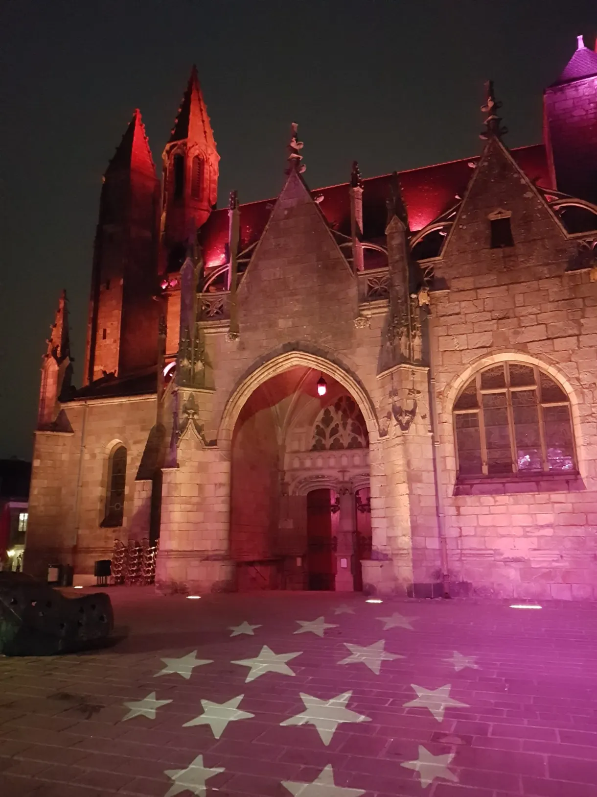 Luminous stars projected onto the ground in front of the pink church