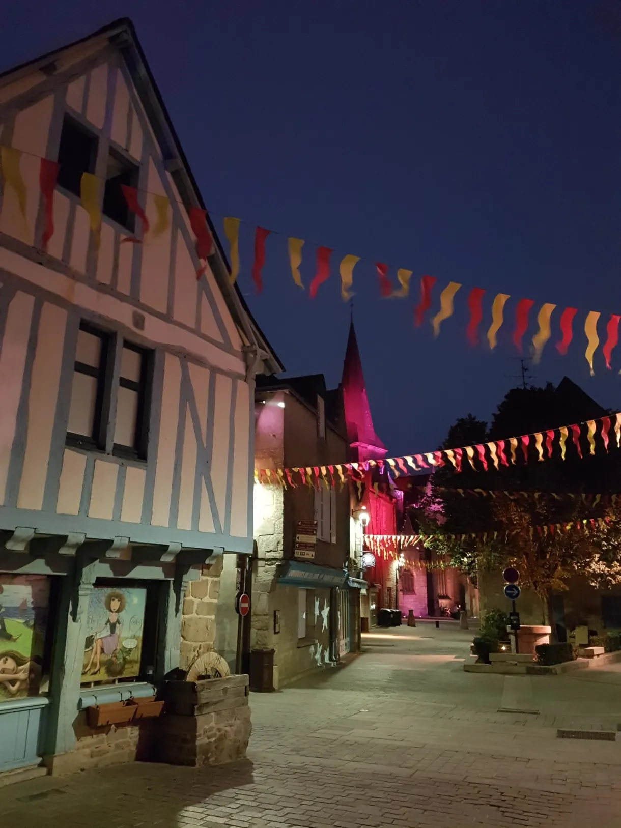 Half-timbered house and bunting on a square at dusk