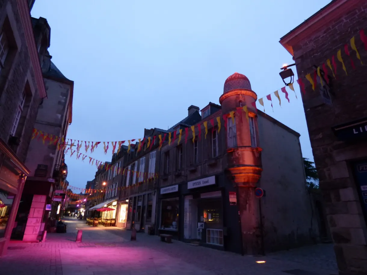 Shopping street and lit shop windows under a pink light