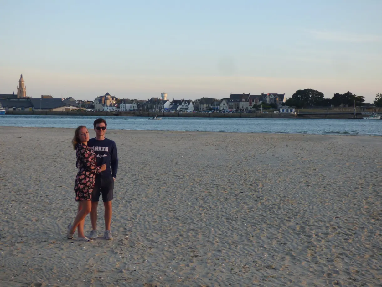 Couple embracing on the sand, seafront on the horizon