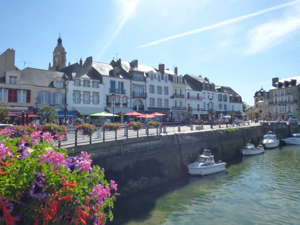 Pale facades lined up along the flower-decked quay
