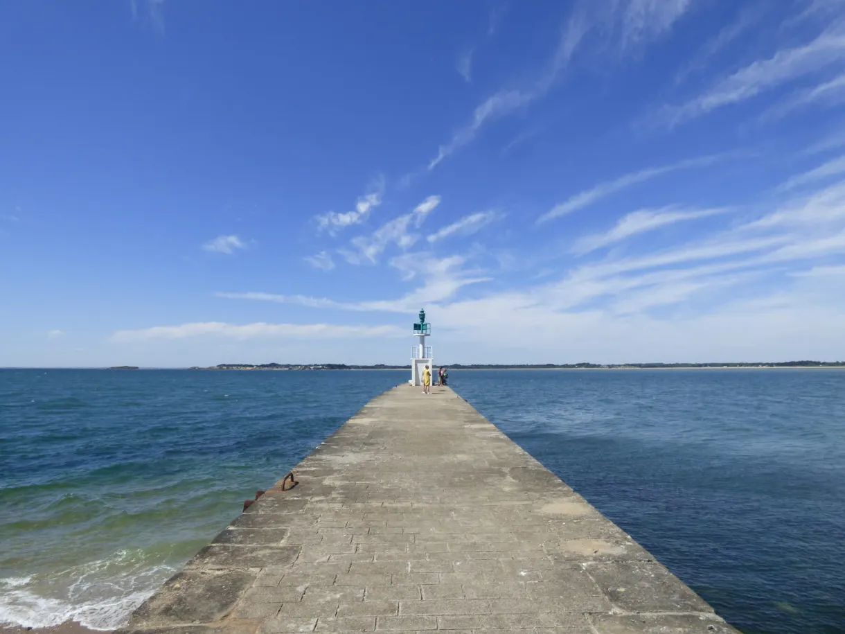 Jetty reaching straight out to sea towards a beacon