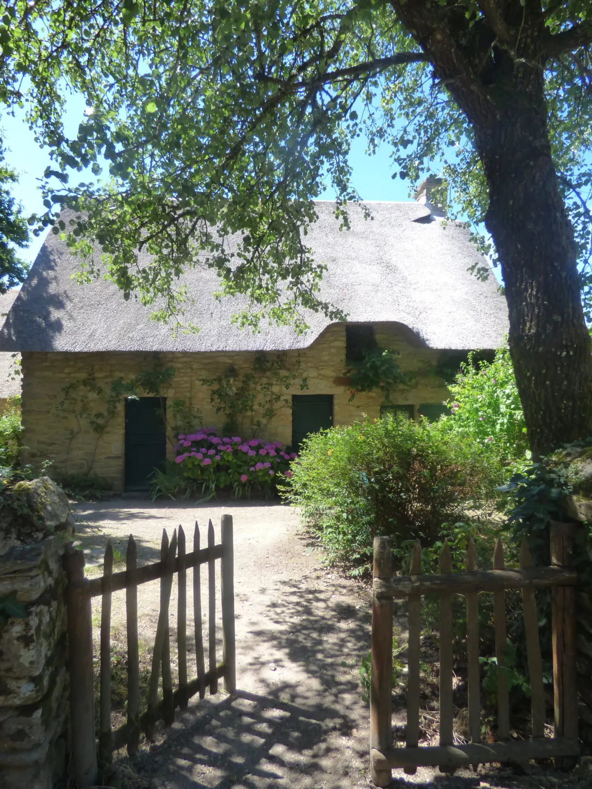 Reed-thatched cottage behind a wooden gate