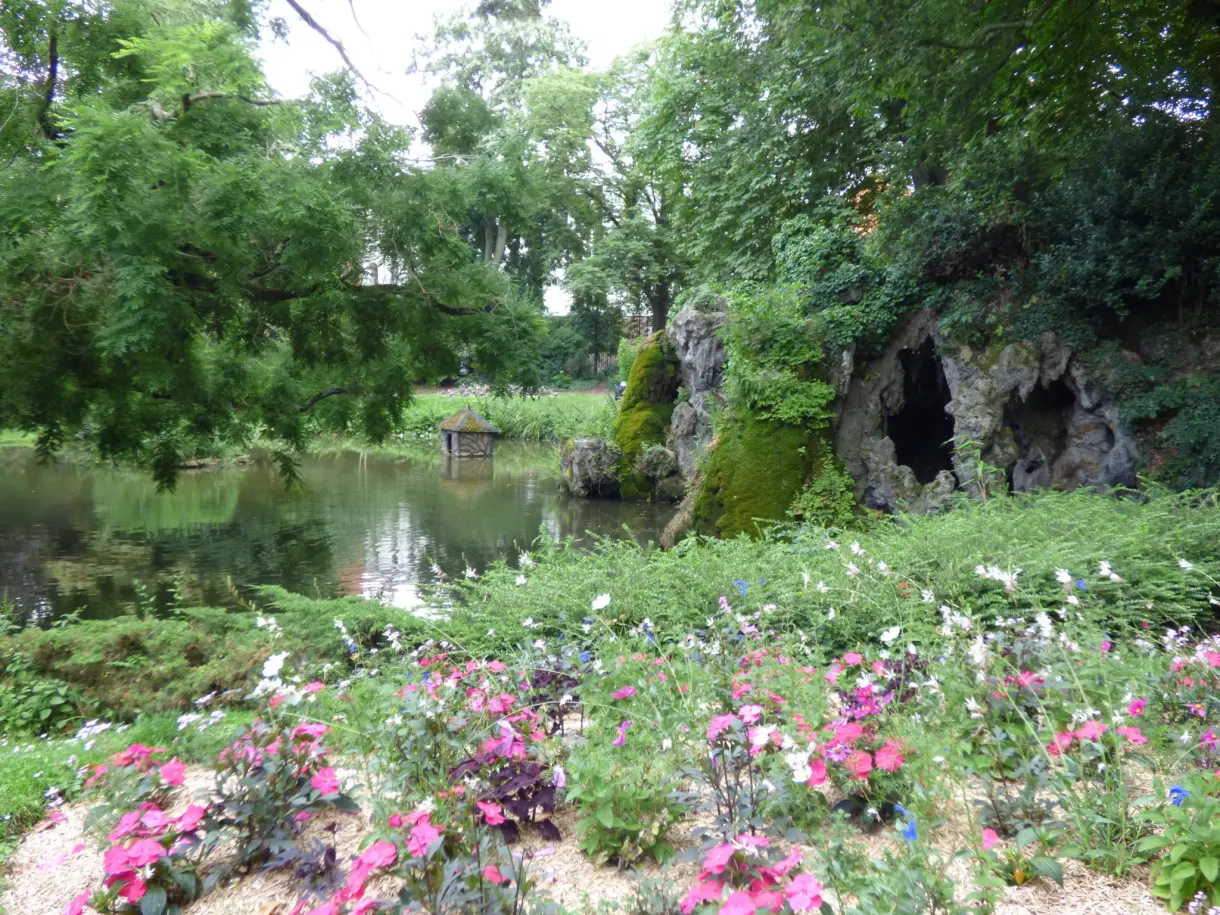 Massifs de fleurs roses au bord d'un étang de rocaille