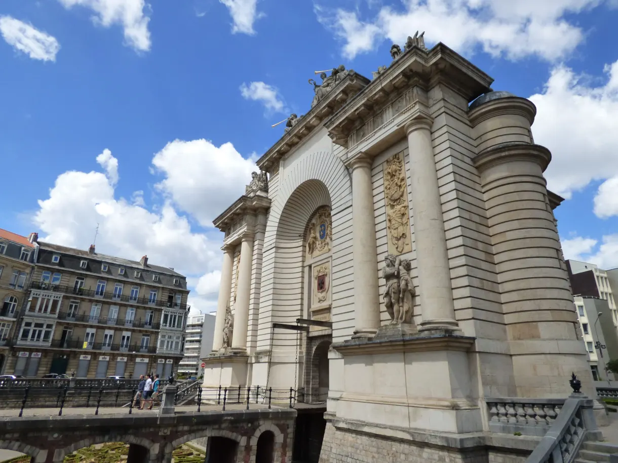 Arche sculptée de la porte monumentale sous les nuages
