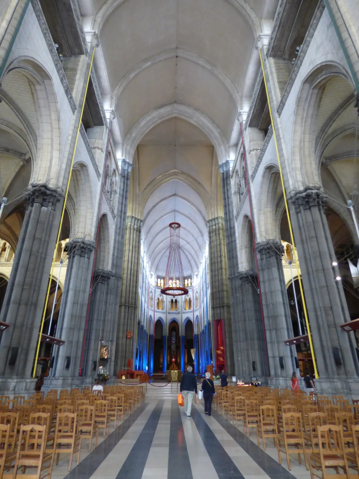 Nef aux hautes colonnes claires et rangées de chaises