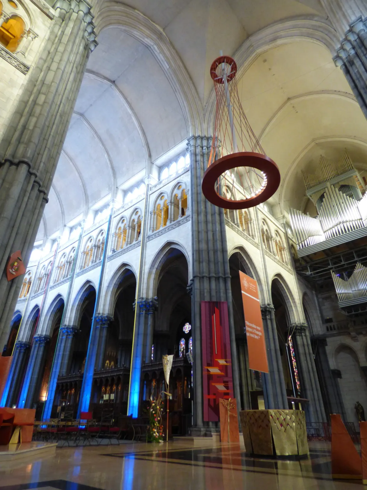 Bas-côté éclairé de bleu et grand lustre circulaire