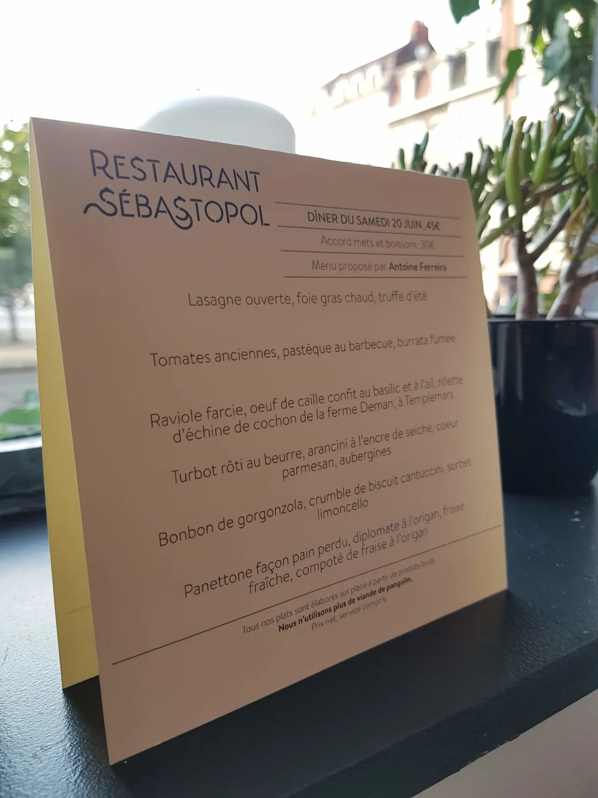 Menu manuscrit d'un restaurant posé sur un pupitre