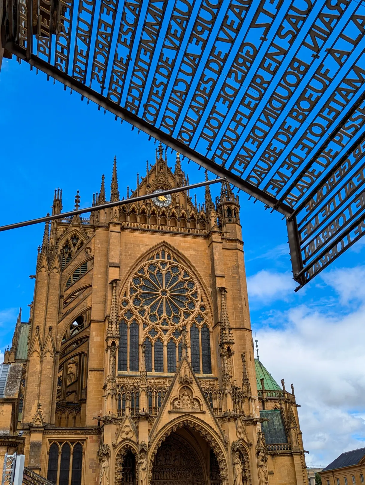 Rosace et portail de la cathédrale Saint-Étienne sous une ombrière ajourée de lettres