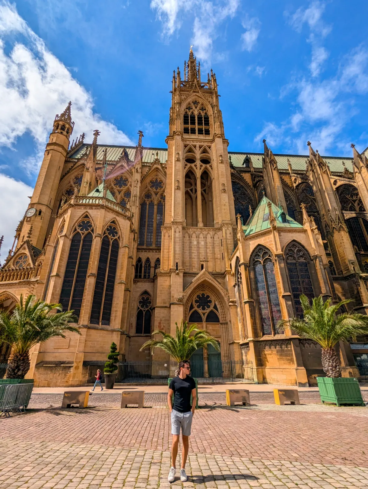 Voyageur devant le flanc gothique de la cathédrale Saint-Étienne et ses palmiers en bacs