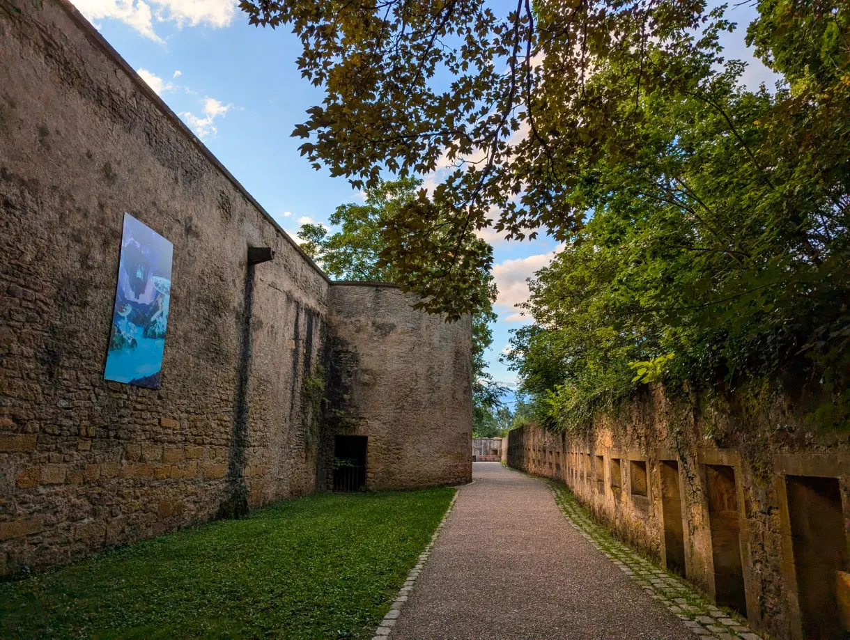 Chemin longeant le rempart médiéval, œuvre imprimée accrochée à la pierre