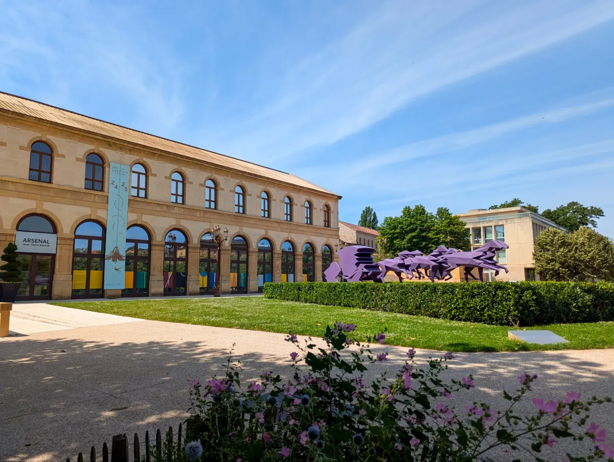 Façade de l'Arsenal et sculpture violette de chevaux sur la pelouse