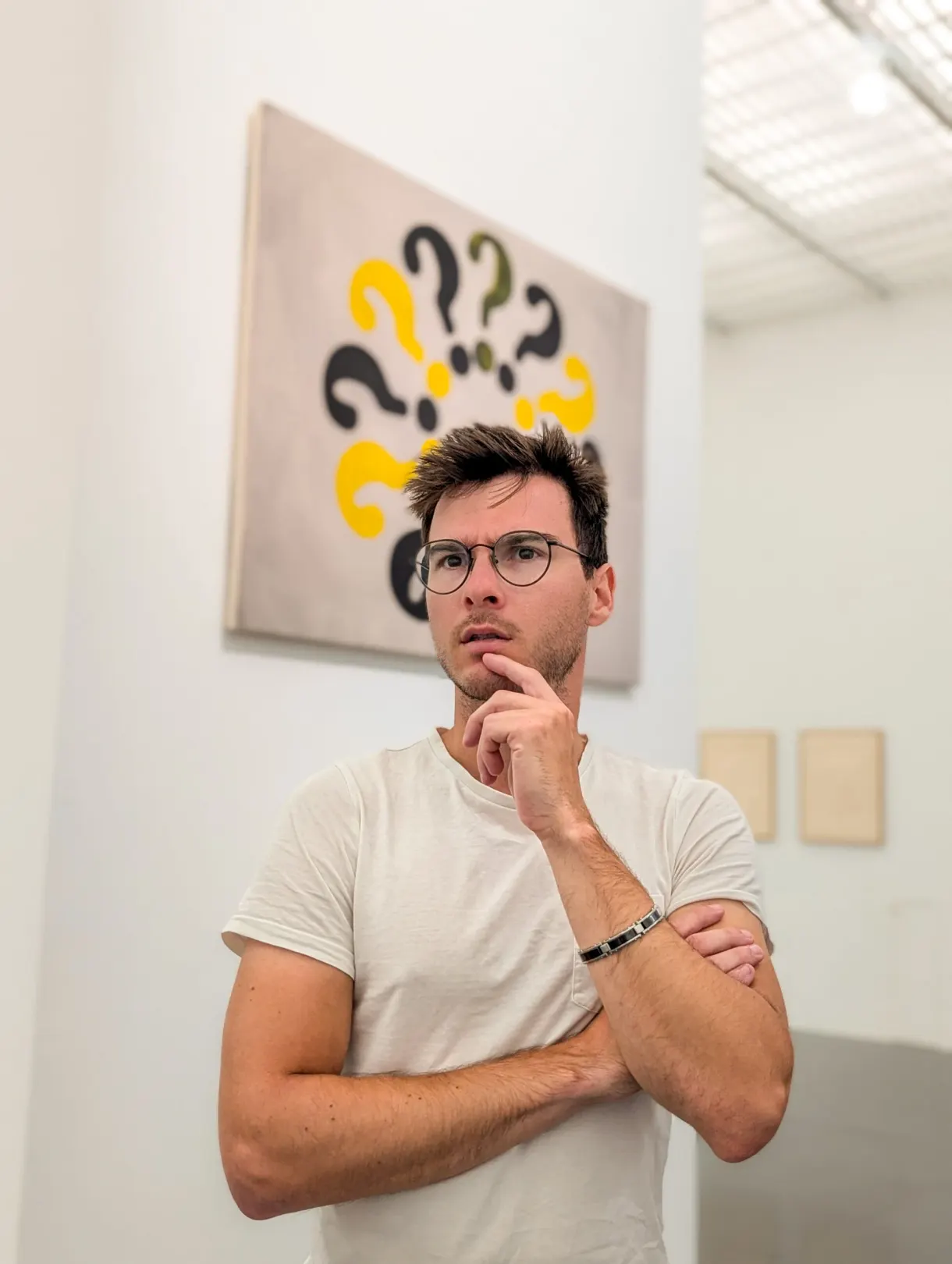 Visiteur pensif devant un tableau couvert de points d'interrogation