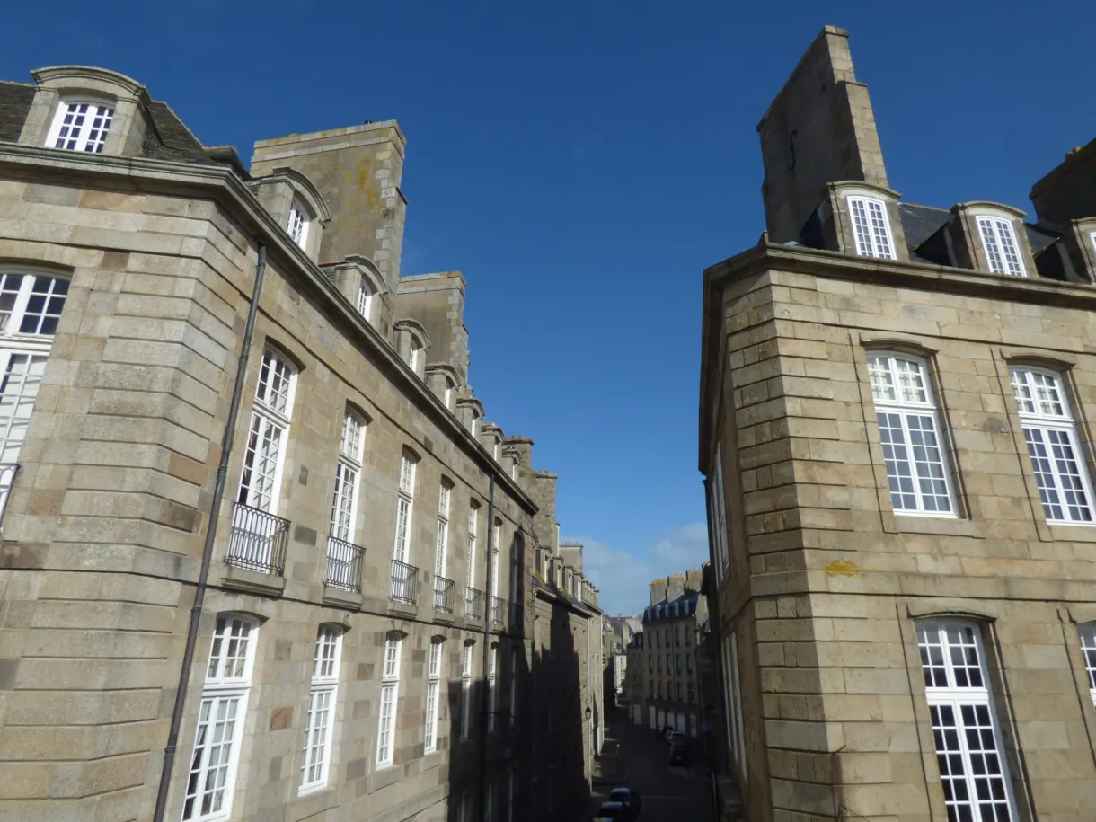 Hautes façades de granit aux fenêtres blanches dans une rue étroite