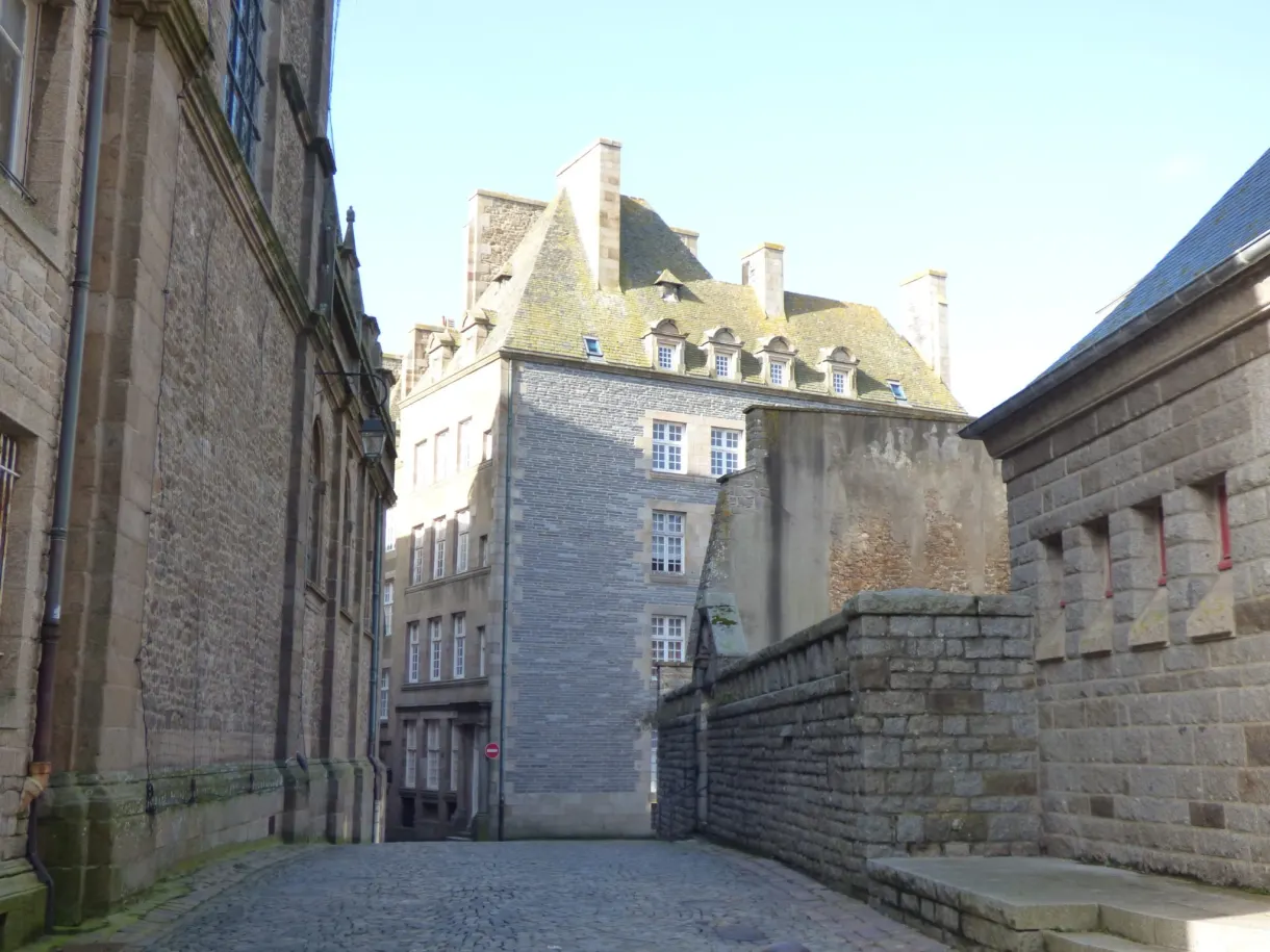Hôtel particulier de granit sur une place pavée déserte