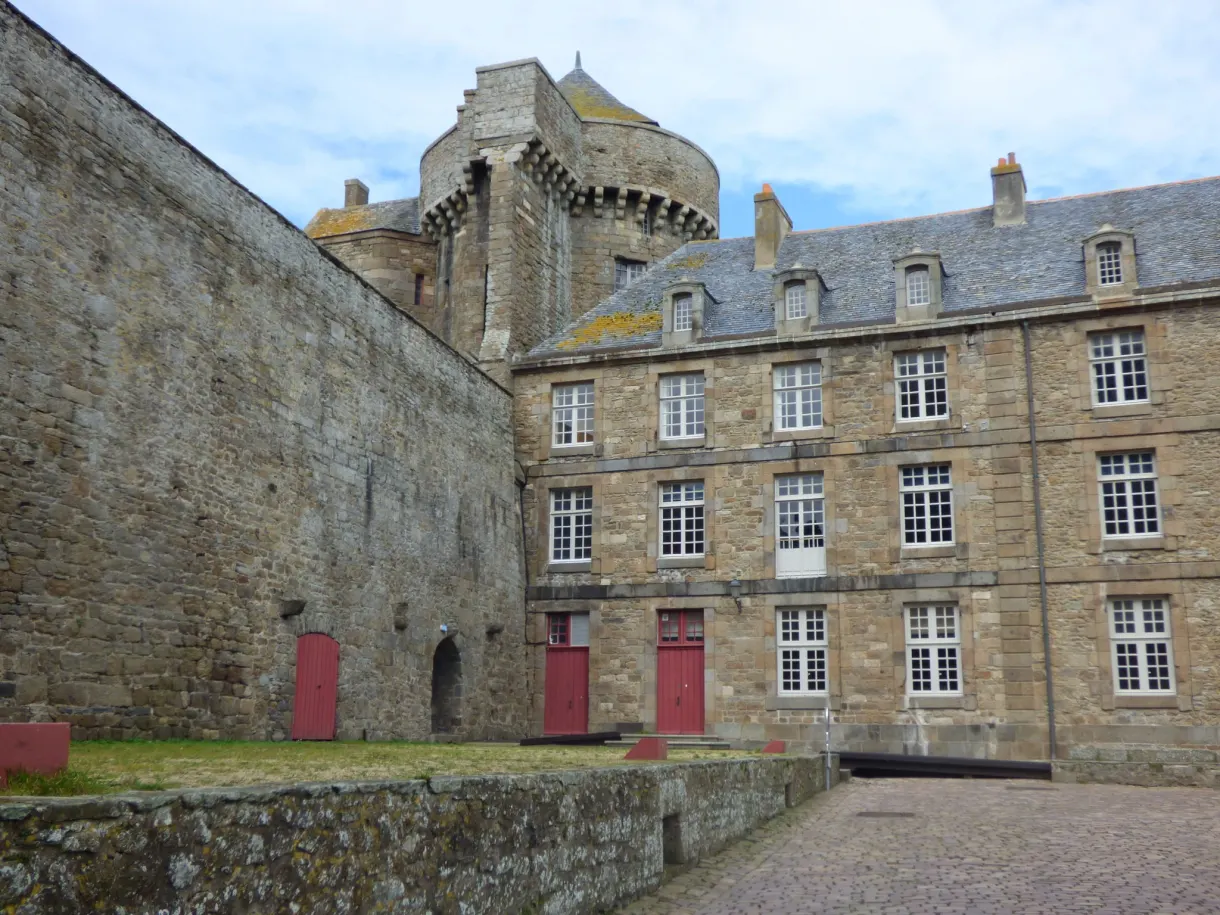 Cour du château, courtine de granit et portes peintes en rouge