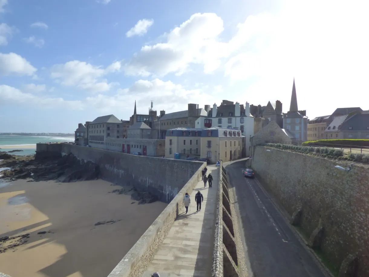 Promeneurs sur le chemin de ronde au-dessus de la grande plage