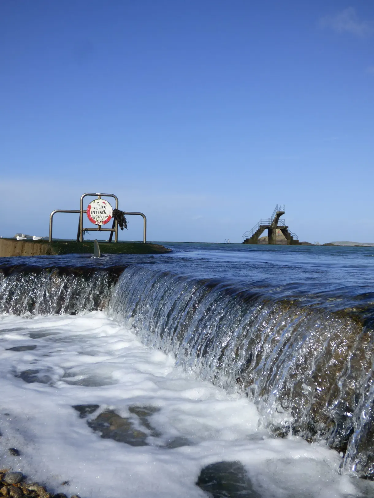 Eau débordant en cascade du bassin de la piscine de mer
