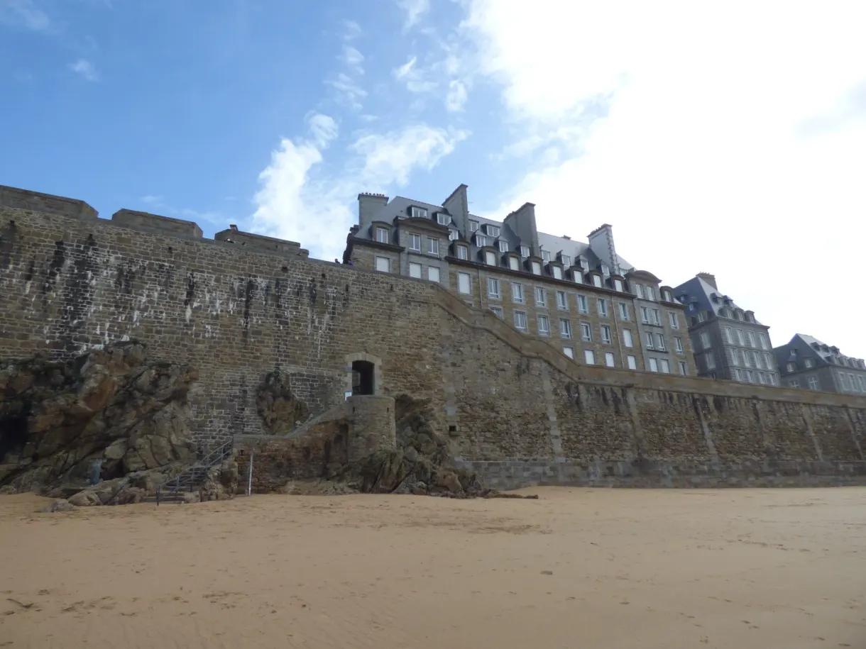 Immeuble d'angle et courtine de granit vus depuis la plage
