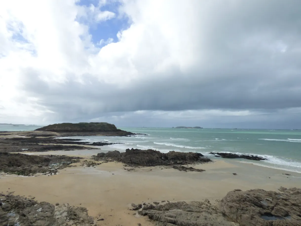 Averse traversant le ciel au-dessus de la mer et d'un îlot