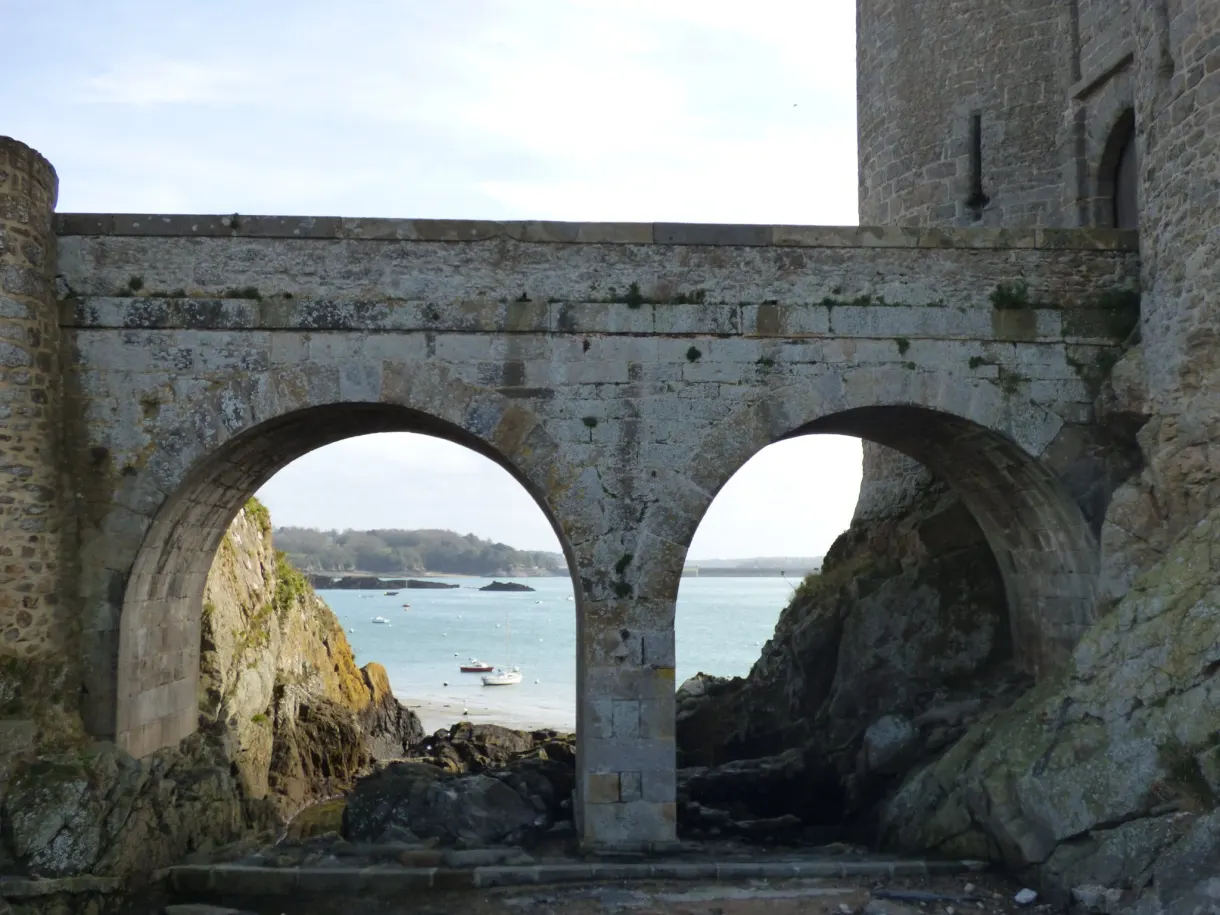 Arches de pierre d'un ancien édifice ouvertes sur la mer