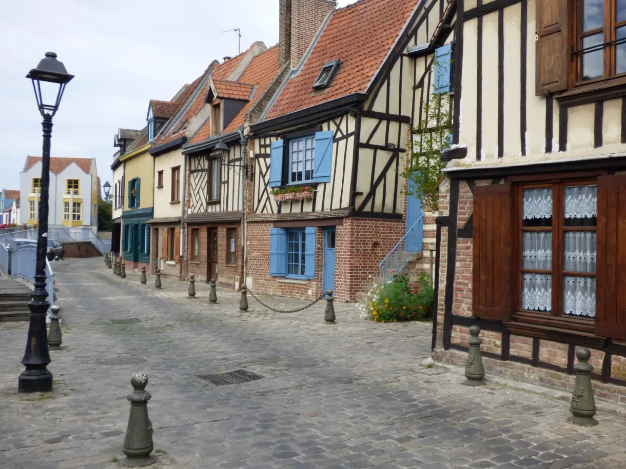 Cobbled street lined with half timbered houses with colourful shutters