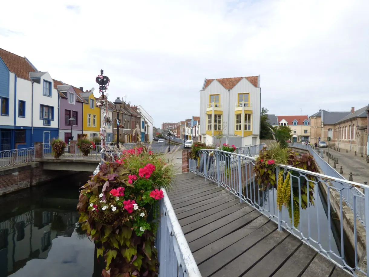 Flower decked footbridge spanning the canal of the Saint-Leu quarter