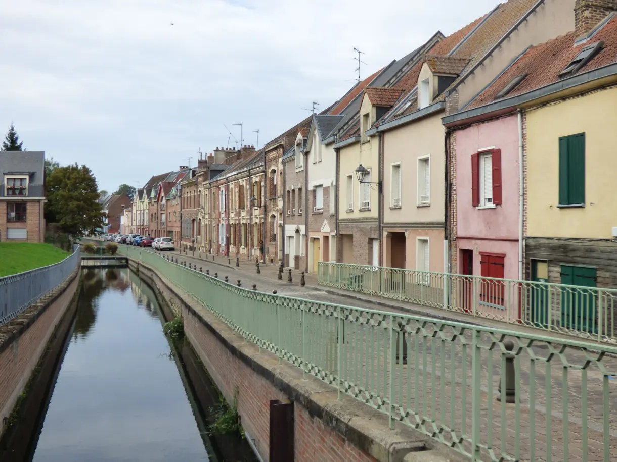 Straight canal between the quays and the pastel facades